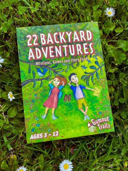 Book titled '22 Backyard Adventures' on grass with flowers. Gumnut Trails Guide