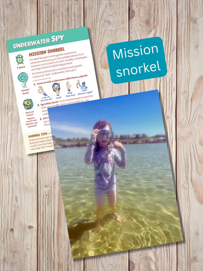 Child snorkeling with an 'Underwater Spy' mission card on a wooden surface. Gumnut Trails Beach Adventure Guide