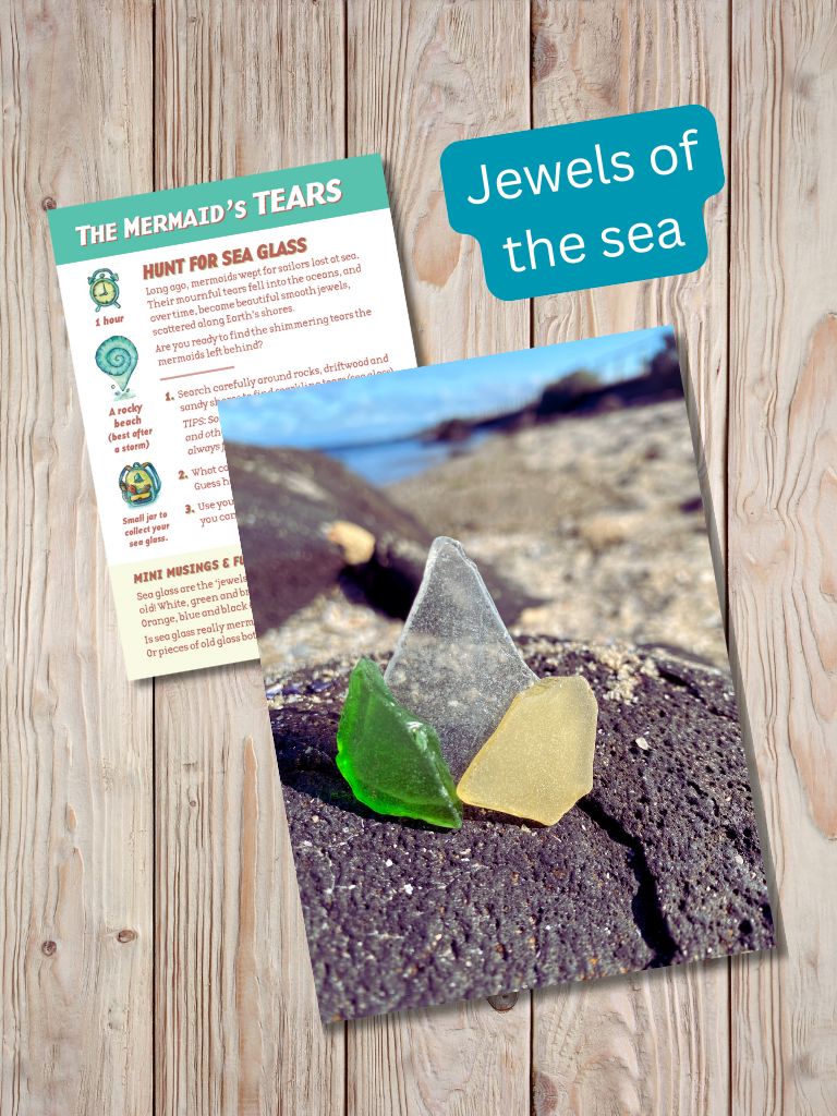 Two pieces of paper with images and text on a wooden surface, featuring 'The Mermaid's Tears' and 'Jewels of the sea'. Gumnut Trails Beach Guide